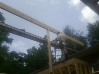 Carpenter setting a ridge beam over a new addition frame — Ice Dam Removal by Roofing Brothers in Jackson Springs