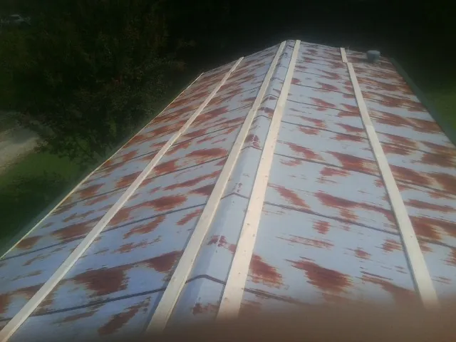 Rusted metal roof panels with new wood purlins before replacement — Storm Damage Roof Repair in Jackson Springs by Roofing Brothers