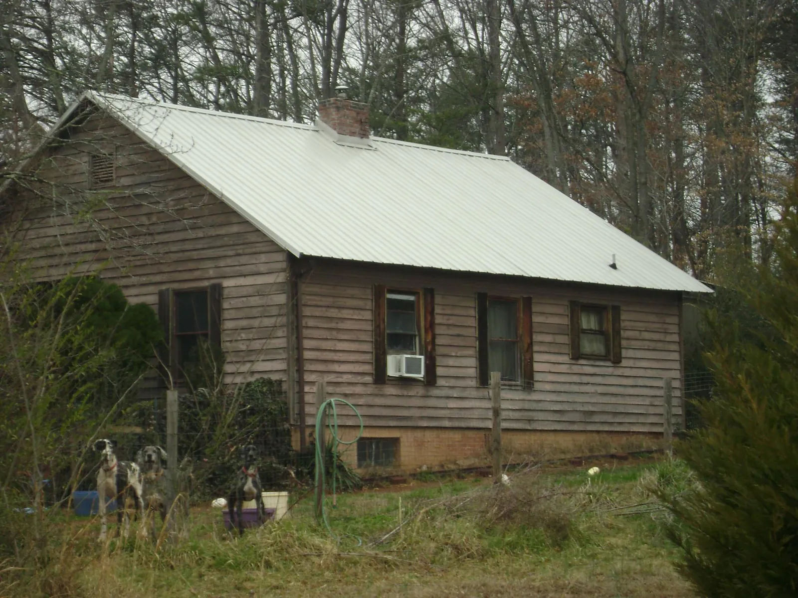 White metal roof on an old wood sided farmhouse, from a Metal Roof Installation job in Jackson Springs